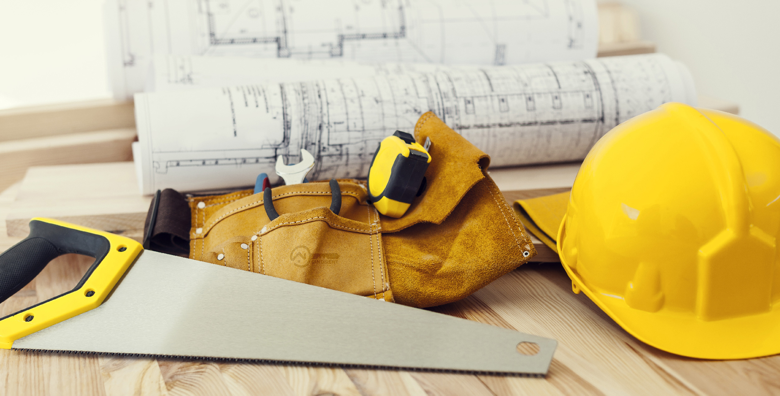 Hard hat, tool belt, and tools on a workbench